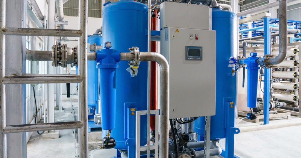 Pourquoi choisir des compresseurs à vitesse fixe plutôt qu'un variateur de fréquence ? - Compresseur d'air américain Two blue refrigerated air dryers in a compressed air system with silver-colored metal pipes.