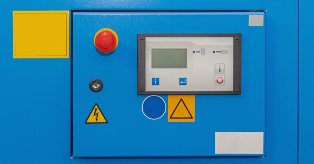 Larger Air Compressors vs Multiple Compressors in Series - US Air Compressor A control panel on a blue air compressor. A yellow sticker with a black lightening bolt in the center is on the panel.